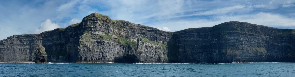 The Cliffs of Moher seen from a cruise boat with O'Brien's Tower on top, the sea view on a Cliffs of Moher tour from Dublin with a boat ride, Ireland